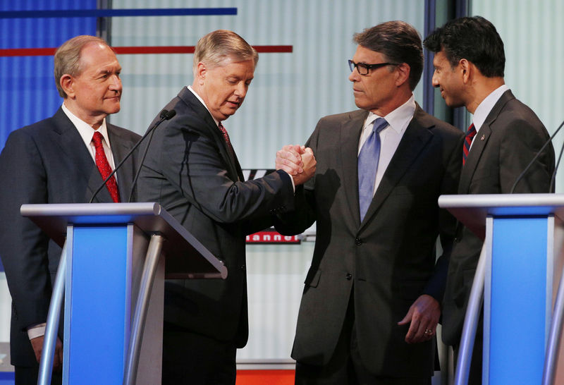 © Reuters. Republican presidential candidates talk in the midst of a break at a Fox-sponsored forum for lower polling candidates held before the first official Republican presidential candidates debate of the 2016 U.S. presidential campaign in Cleveland