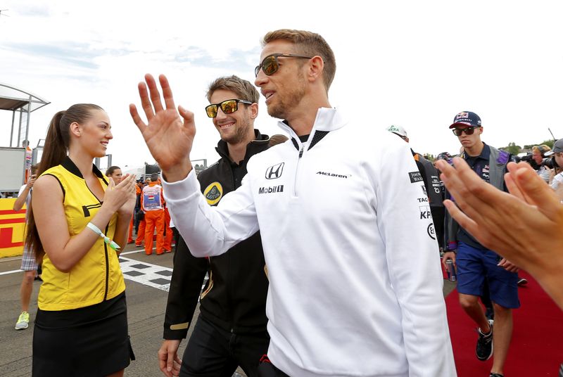 © Reuters. McLaren Formula One driver Button of Britain and Lotus Formula One driver Grosjean of France arrive for the drivers parade before the Hungarian F1 Grand Prix at the Hungaroring circuit, near Budapest
