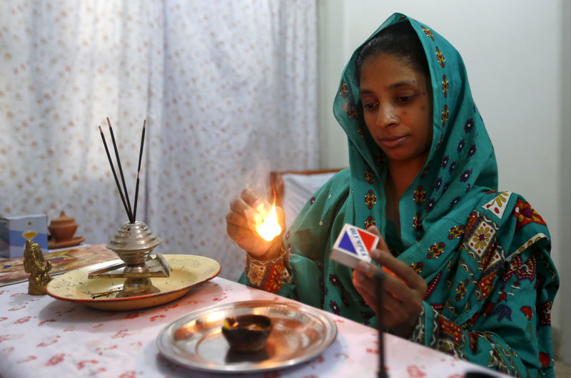 © Reuters. Geeta lights a match as she prepares to pray at the Bilquis Edhi Foundation in Karachi