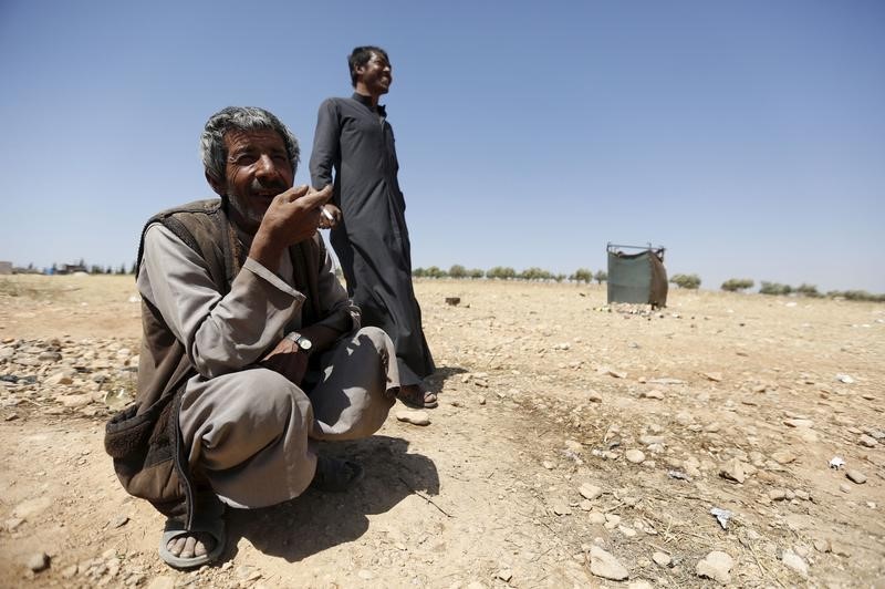 © Reuters. Homens que fugiram de Palmyra após invasão do Estado Islâmico, em Homs, na Síria