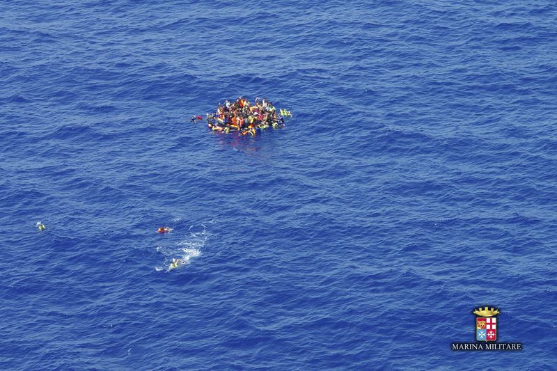 © Reuters. Surviving migrants are seen aboard a life-rafts in the area where their wooden boat capsized and sank off the coast of Libya