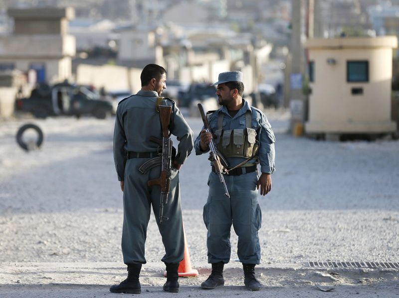 © Reuters. Afghan policemen keep watch at the site of an attack after an overnight battle outside a base in Kabul, Afghanistan