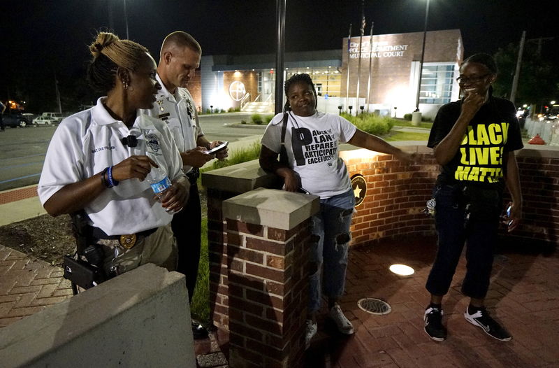 © Reuters. Ferguson police Sgt. Dominica Fuller talks with protesters outside the police department in  Ferguson