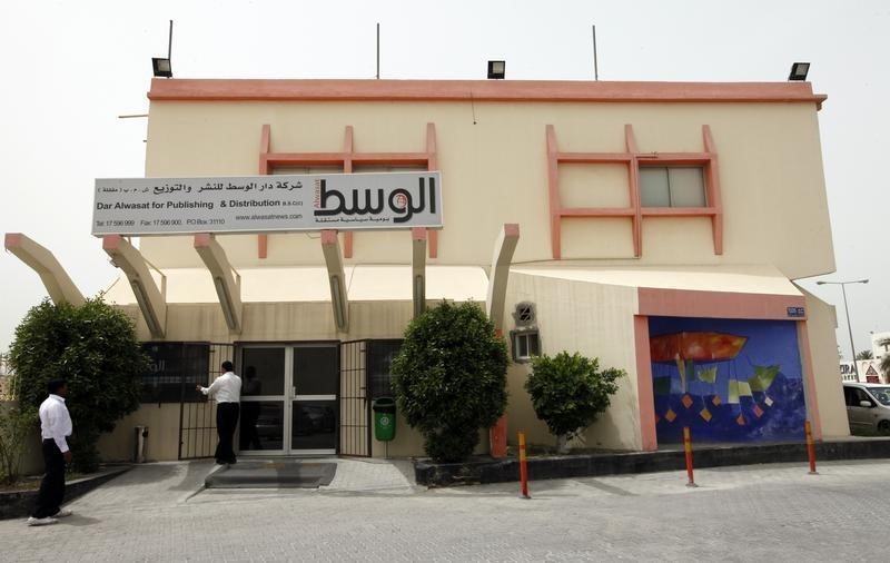 © Reuters. An employee opens the main gate of opposition newspaper Al-Wasat in Manama