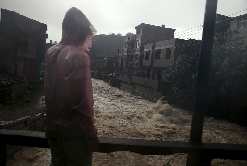 © Reuters. A man watches floodwaters in a heavy rain at a town hit by Typhoon Soudelor in Ningde, Fujian province