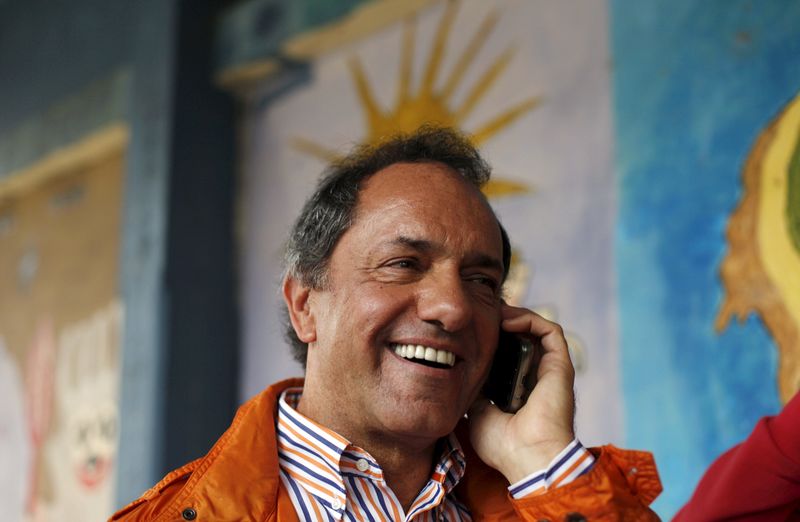 © Reuters. Scioli, Buenos Aires' province Governor and presidential candidate, talks on the phone after casting his vote in a polling station in Buenos Aires