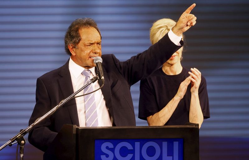 © Reuters. Governador da Província de Buenos Aires e candidato presidencial, Daniel Scioli, ao lado de sua esposa durante discurso, na Argentina