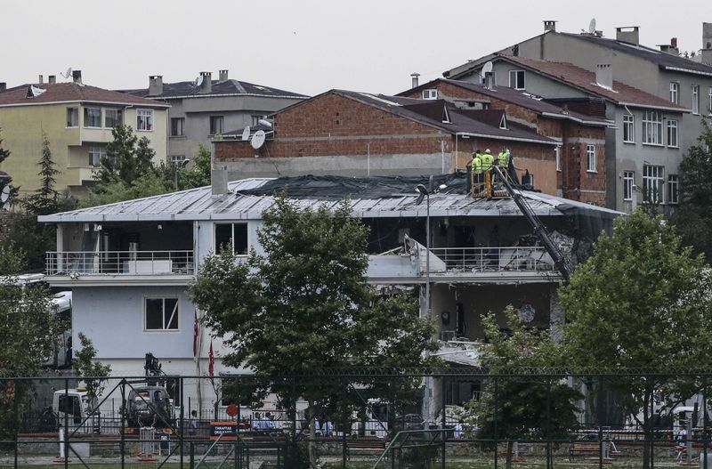 © Reuters. Workers cover a police station damaged after an attack in Istanbul