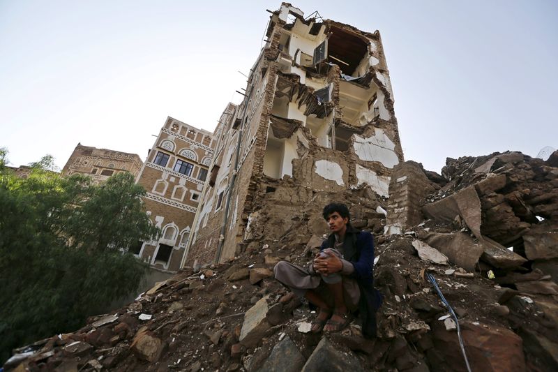 © Reuters. Man sits at a site which the Houthi-led authorities say was hit by a Saudi-led air strike at the old quarter of Yemen's capital Sanaa 