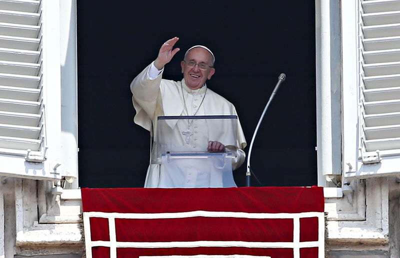 © Reuters. Pope Francis waves as he leads the Angelus prayer from the window of the Apostolic palace in Saint Peter's Square at the Vatican