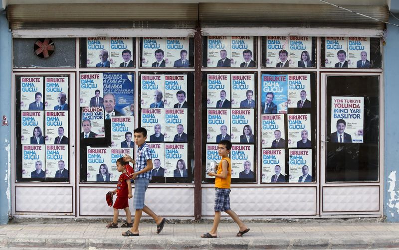 © Reuters. Boys walk past by local headquarters of the ruling AK Party in Karkamis