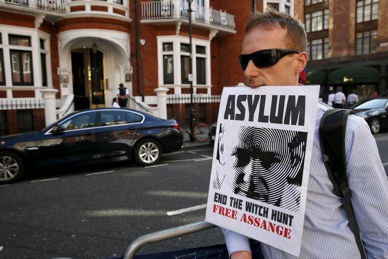 © Reuters. A supporter of Wikileaks founder Julian Assange holds a placard with his mouth during a gathering outside the Ecuador embassy in London