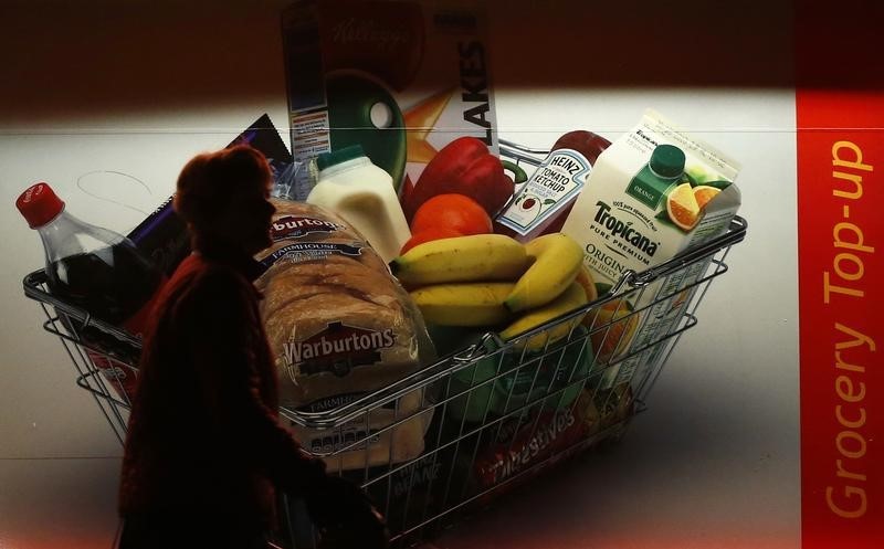 © Reuters. A woman walks past a grocery store in Loughborough