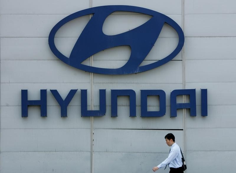 © Reuters. A South Korean walks past the logo of Hyundai Motor group at its headquarters in Seoul April 27, 200..
