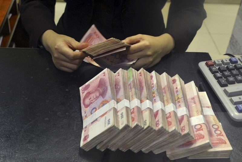 © Reuters. A clerk counts 100 Chinese yuan banknotes at a branch of China Merchants Bank in Hefei