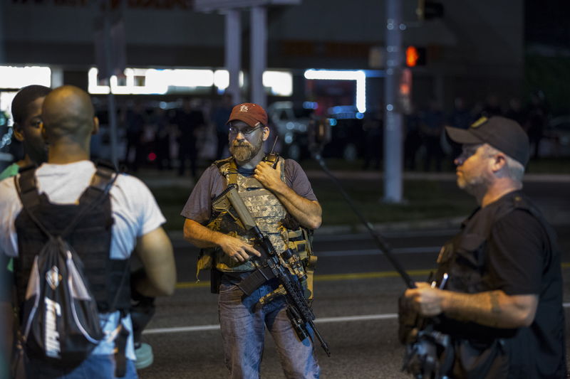 © Reuters. Members of the Oath Keepers walk with their personal weapons on the street during protests in Ferguson, Missouri