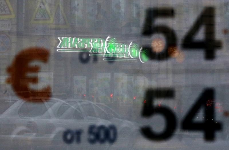 © Reuters. An office of Sberbank is reflected in a window with a board displaying currency exchange rates, in St. Petersburg