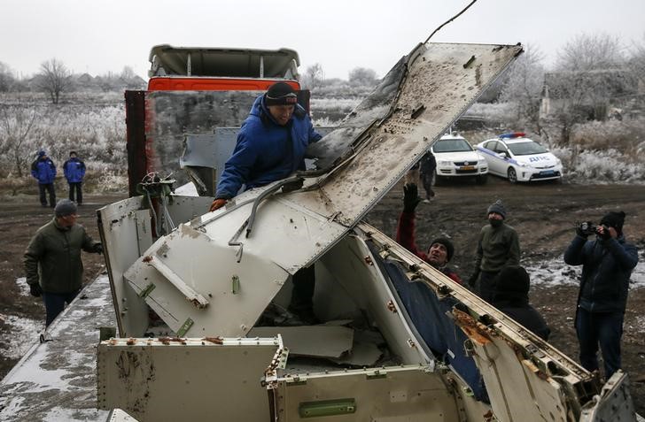 © Reuters. Trabalhador transportanto parte dos destroços da aeronave da Malaysia Airlines, na região de Donetsk, na Ucrânia