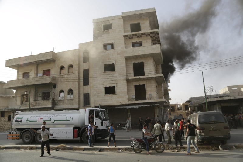 © Reuters. Moradores observam um prédio atingido por bomba