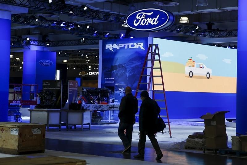 © Reuters. People walk near the Ford exhibit area of the New York International Auto Show at the Javits Center ahead of the event in New York 