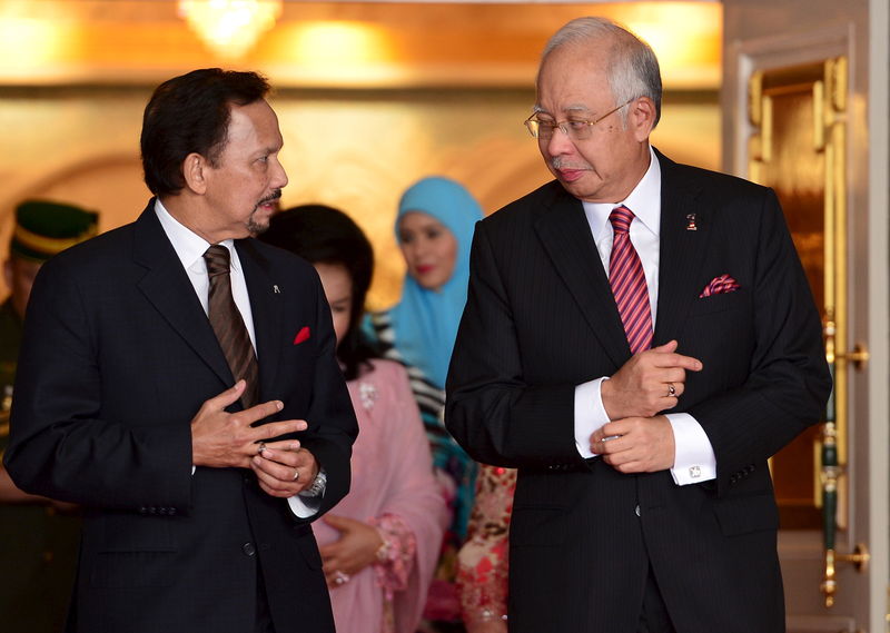 © Reuters. Brunei's Sultan Hassanal Bolkiah walks with Malaysia's PM Najib during the 19th Annual Leaders Consultation at Nurul Iman Palace in Bandar Seri Begawan