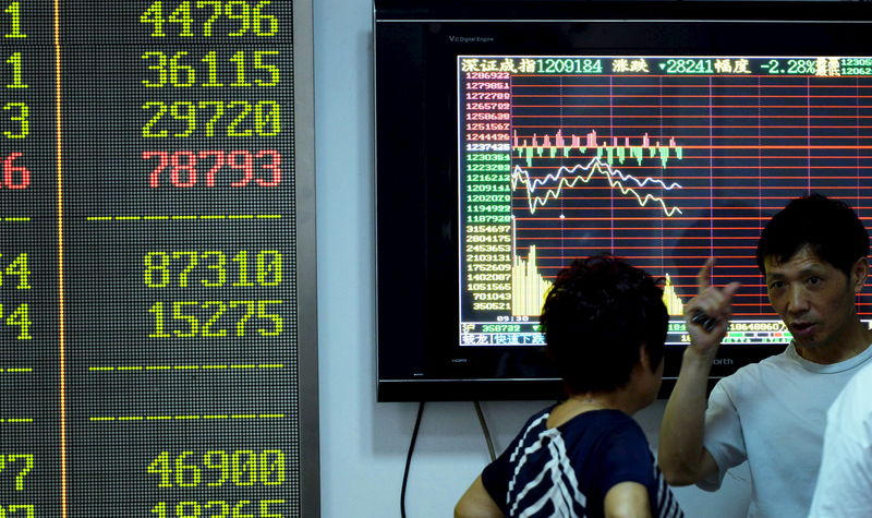 © Reuters. Investors talk in front of a screen showing stock information at a brokerage house in Hangzhou