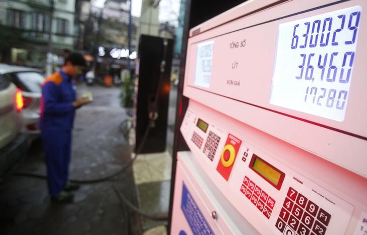 © Reuters. A pump attendant counts money at a petrol station in Hanoi