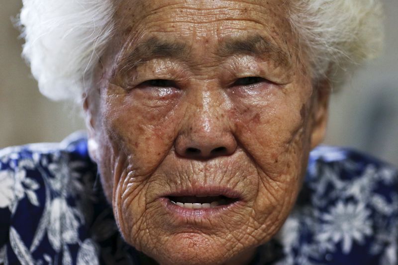 © Reuters. مسن يضرم النار في نفسه من أجل نساء كوريا خلال احتجاج ضد اليابان