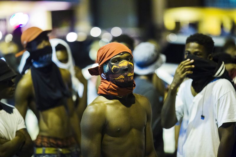 © Reuters. Jovens aguardam para ver o que acontece em Ferguson