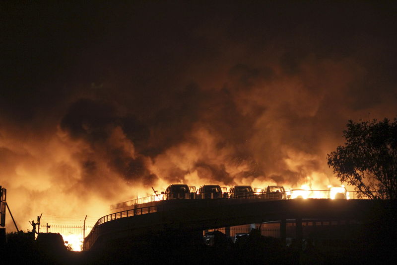 © Reuters. Veículos queimam após explosões em Tianjin