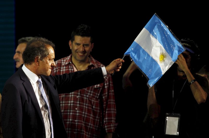 © Reuters. Daniel Scioli, Buenos Aires' province governor and presidential candidate, waves an Argentine national flag in Buenos Aires