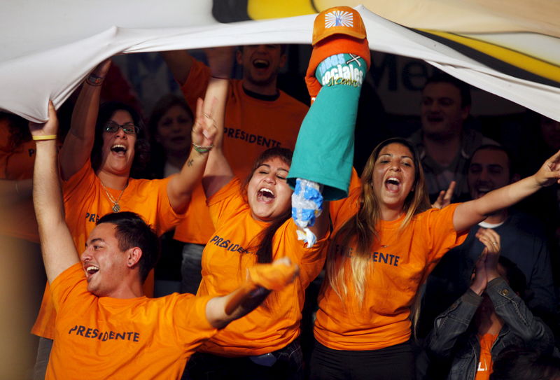 © Reuters. Supporters of Daniel Scioli, Buenos Aires' province governor and presidential candidate, cheer as he speaks in Buenos Aires