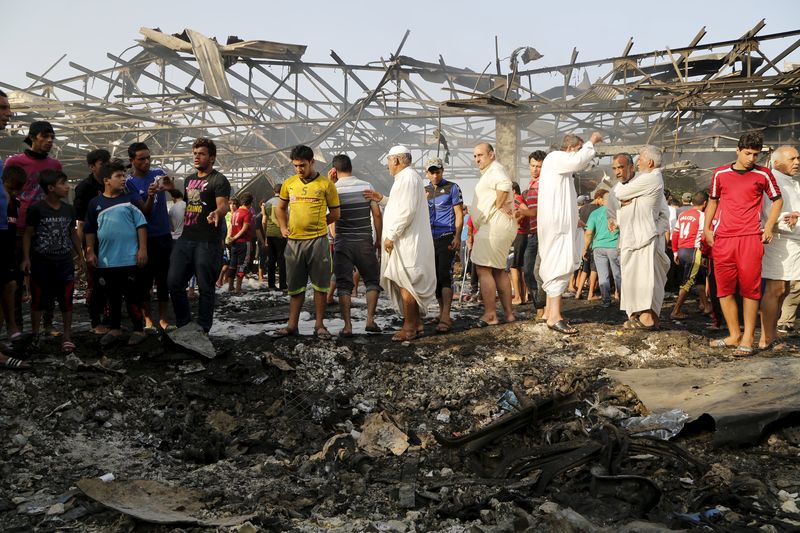 © Reuters. Residents gather at the site of a truck bomb attack at a crowded market in Baghdad
