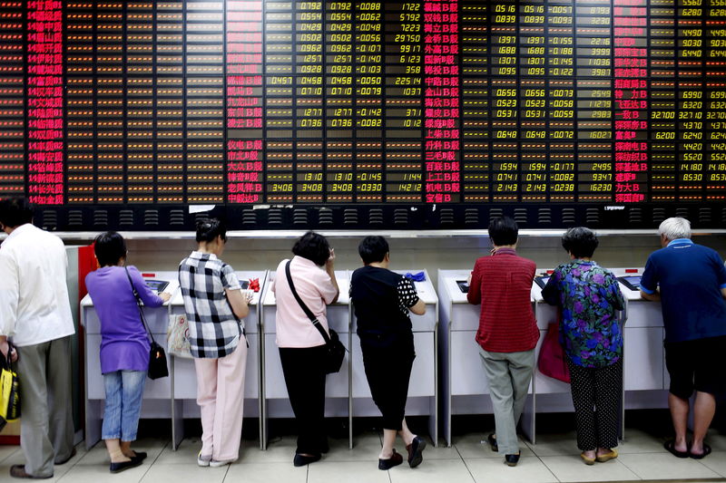 © Reuters. File photo of investors look at computer screens showing stock information at a brokerage house in Shanghai