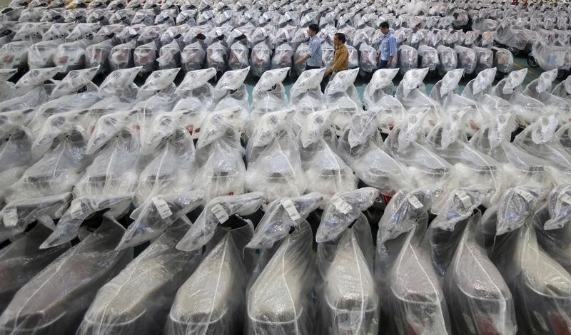 © Reuters. Workers walk among scooters at a Piaggio scooter and motorcycle factory in Vietnam's northern Vinh Phuc province, outside Hanoi 