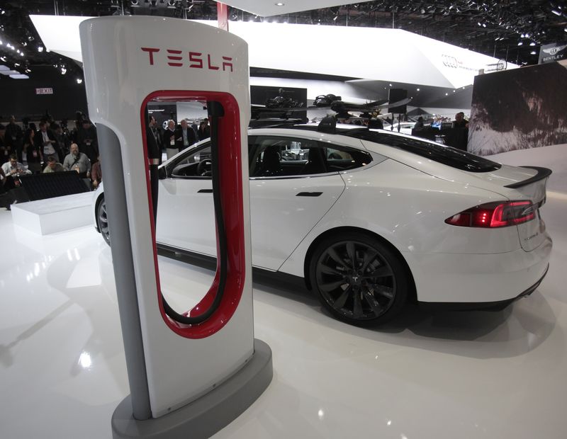 © Reuters. A Tesla S electric car and a charging station are displayed during the press preview day of the North American International Auto Show in Detroit