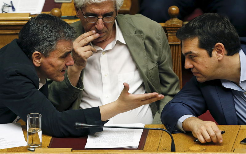 © Reuters. Greek PM Tsipras listens to Finance Minister Tsakalotos as Justice Minister Paraskevopoulos looks on during a parliamentary session in Athens