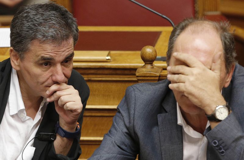 © Reuters. Greek Economy Minister Stathakis and Finance Minister Tsakalotos attend a parliamentary session in Athens