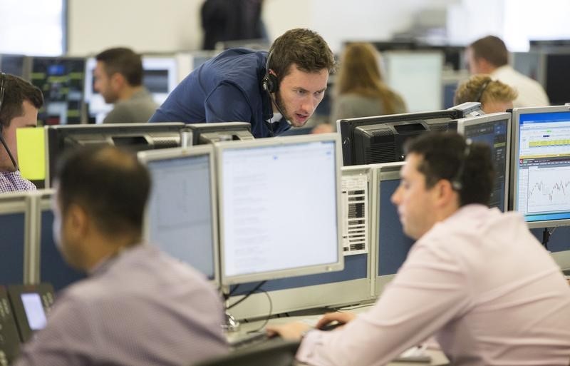 © Reuters. Dealers work on the IG Group trading floor in London, Britain