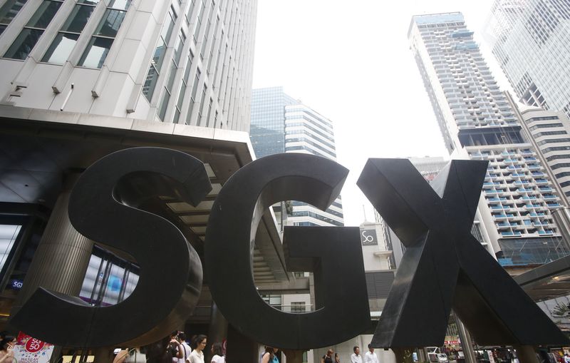 © Reuters. People pass a Singapore Exchange sign outside its premises at the central business district in Singapore 