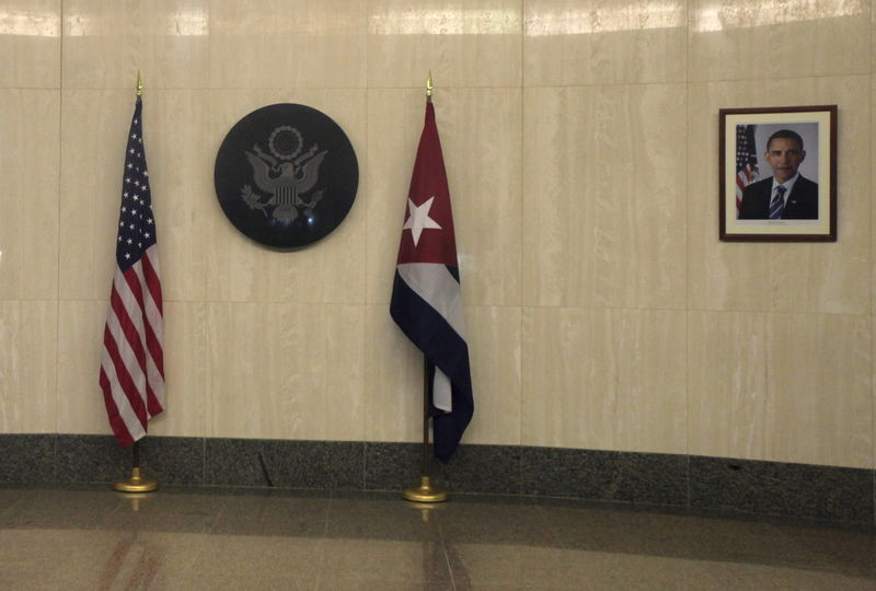 © Reuters. Bandeiras de Cuba e dos Estados Unidos são colocados perto do selo dos EUA e da foto do presidente norte-americano, Barack Obama, na entrada da embaixada dos Estados Unidos em Cuba