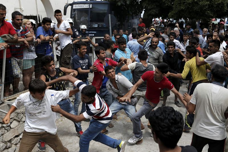 © Reuters. Pakistani, Iranian and Afghani migrants scuffle outside the police station of the city of Kos