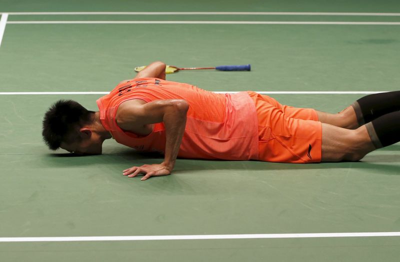 © Reuters. China's Chen Long kisses the court after beating Malaysia's Lee Chong Wei during their men's singles finals badminton match at the BWF World Championships in Jakarta