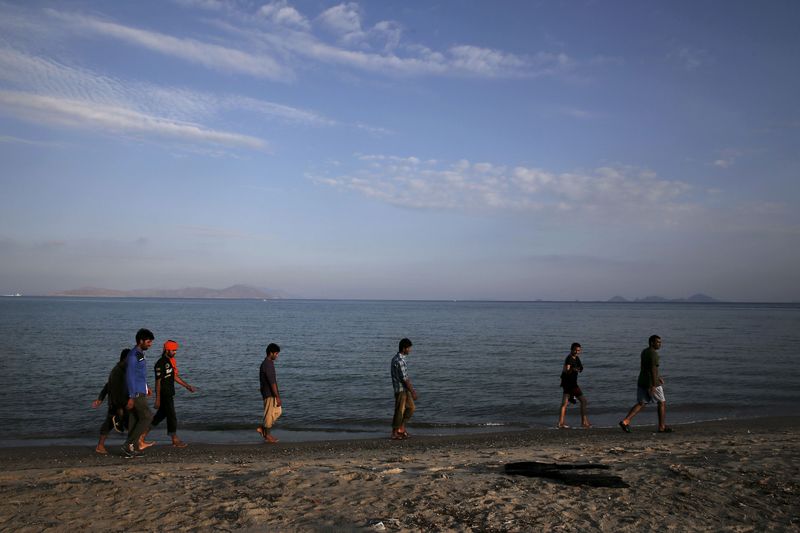 © Reuters. Migrants walk on a beach on the Greek island of Kos