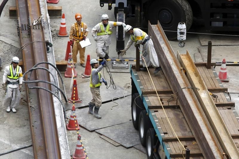 © Reuters. Workers stand at a construction site in central Tokyo