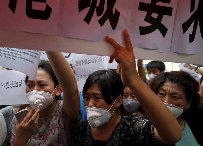 © Reuters. محتجون يطالبون بتعويض عن انفجاري تيانجين بالصين