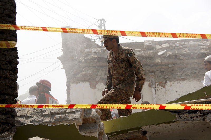 © Reuters. A soldier walks on sections of a collapsed roof after a blast near the home of the home minister of Punjab province, Shuja Khanzada, in Attock