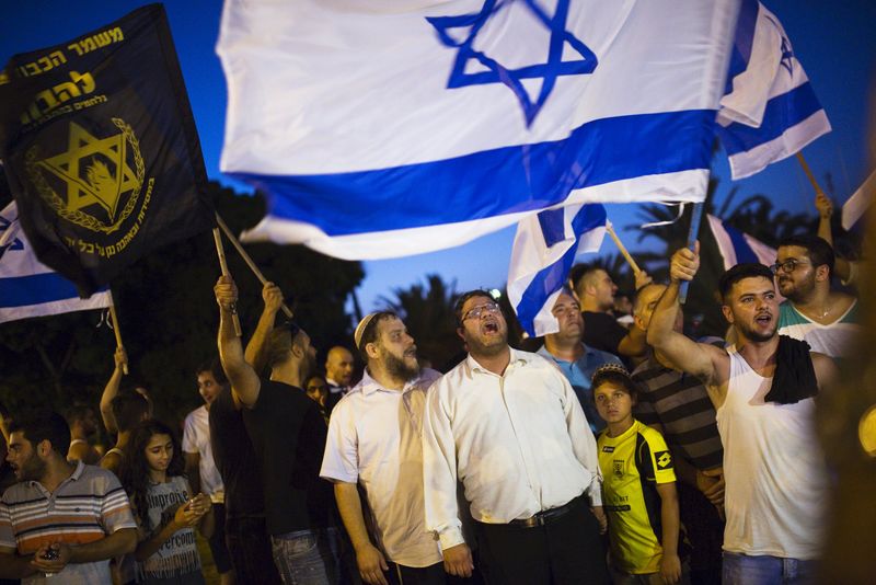 © Reuters. Right-wing activists hold Israeli national flags, during a protest in support of a hunger-striking Palestinian prisoner, Mohammed Allan, in the southern city of Ashkelon