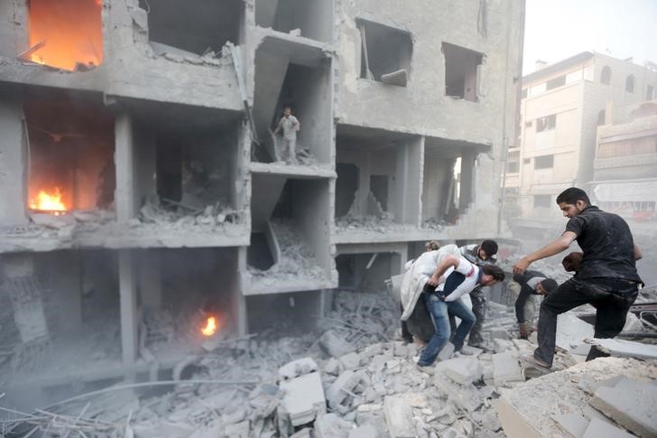 © Reuters. Homem procurando por sobreviventes na área de Douma, na Síria