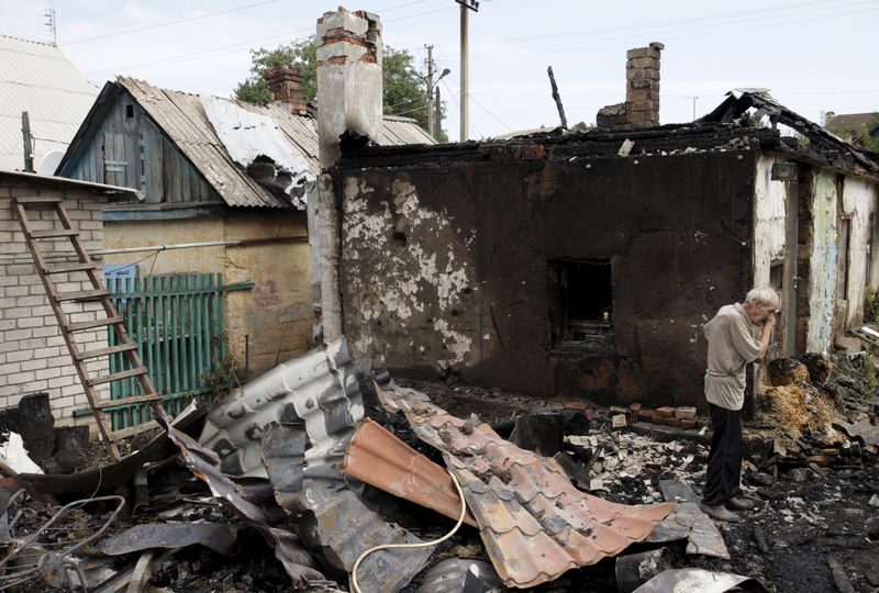 © Reuters. A man cries as he inspects debris while standing outside his damaged house which according to locals was caused by recent shelling in Donetsk